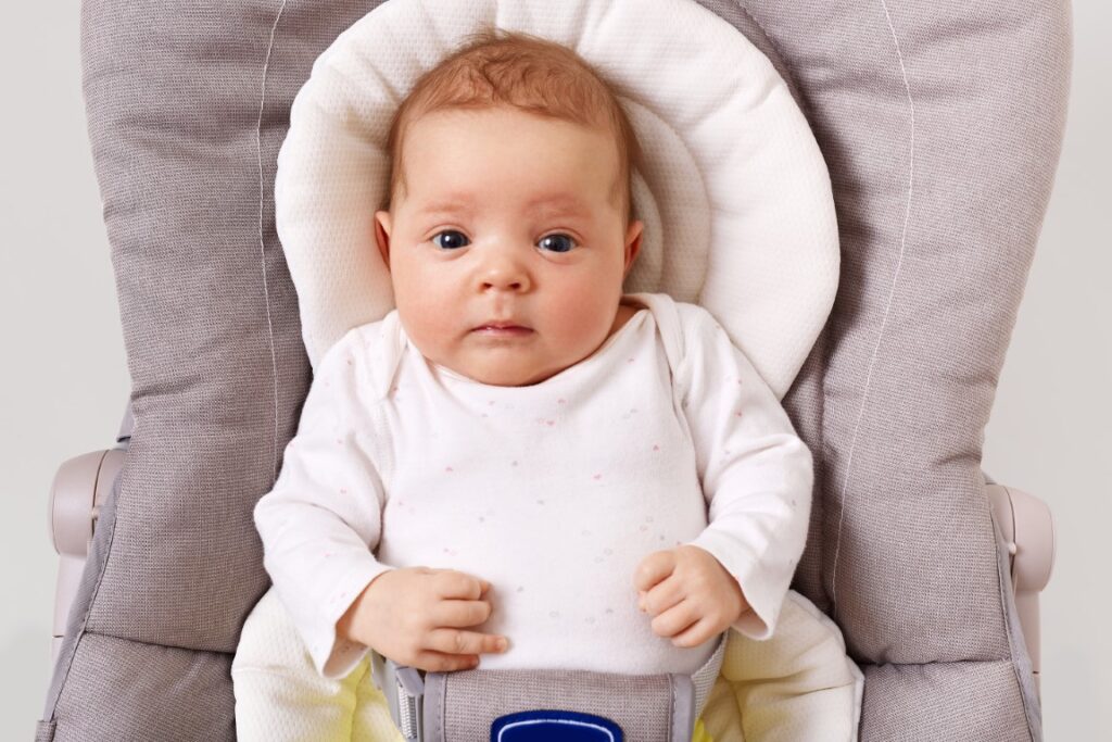 front-view-curious-new-born-baby-wearing-white-podysuit-lying-child-bouncer-chair