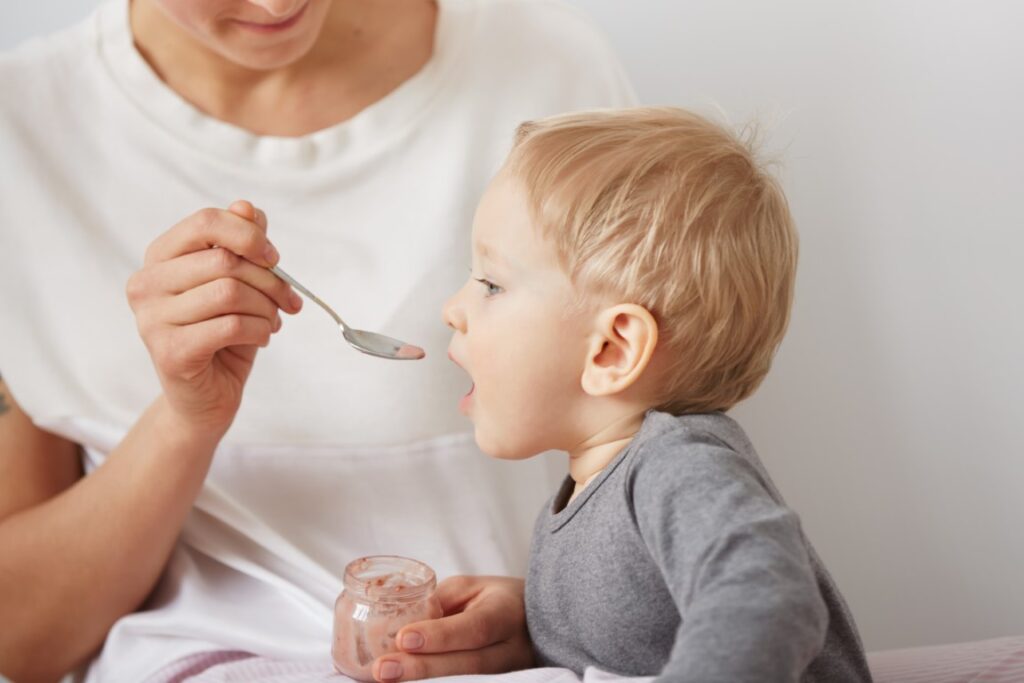 mother-feeding-her-baby-boy-with-spoon