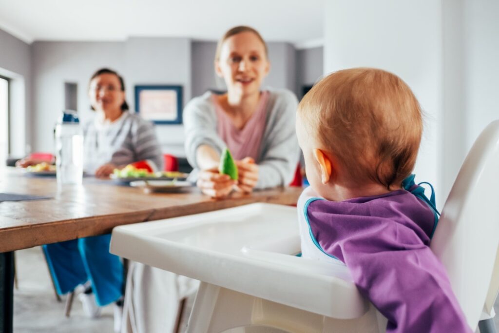 young-mom-feeding-her-child-with-solid-food-dining-room